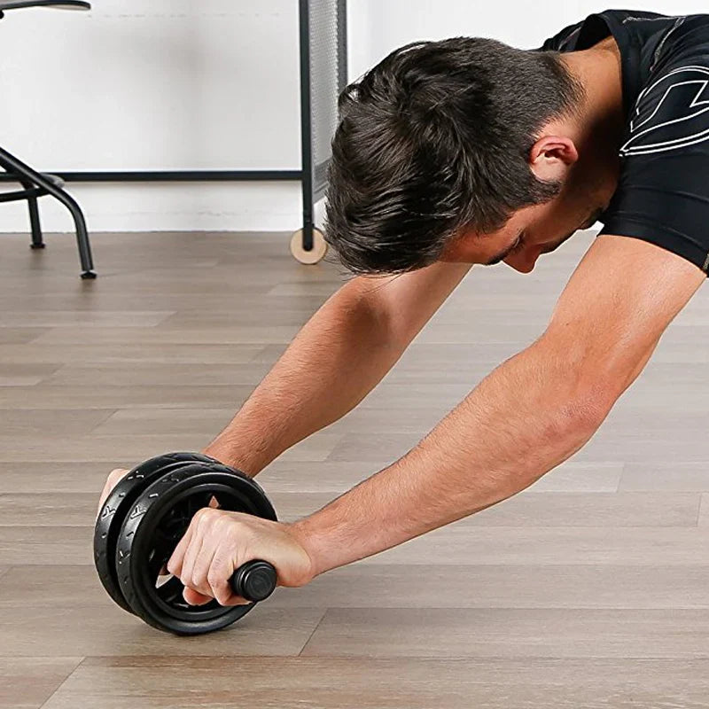 Person using an ab roller on a wooden floor