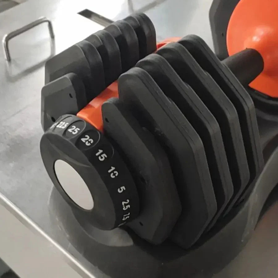 Black adjustable dumbbell on a metallic surface