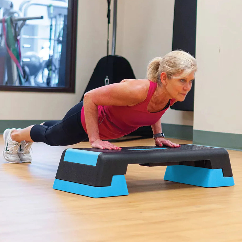 Woman exercising on a step platform in a gym setting