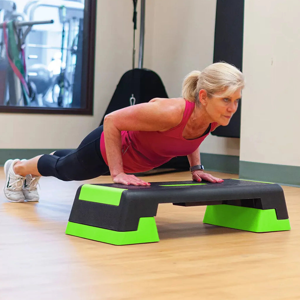Woman exercising on a step platform in a gym setting