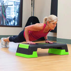 Woman exercising on a step platform in a gym setting