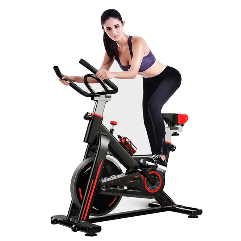 Woman exercising on a stationary bike against a white background