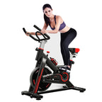 Woman exercising on a stationary bike against a white background