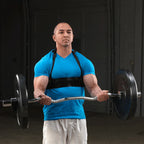Man lifting a barbell with weights in a gym setting
