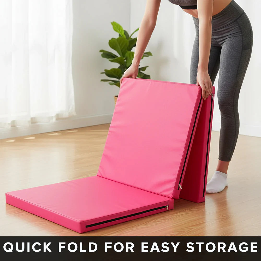 Person folding a pink exercise mat with text 'Quick fold for easy storage' in a room with a plant.