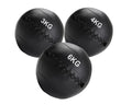 Three black weighted medicine balls with weight markings on a white background