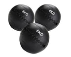 Three black weighted medicine balls with weight markings on a white background