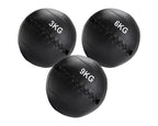 Three black weighted medicine balls with different weights on a white background