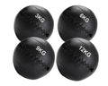 Four black medicine balls with weight markings on a white background