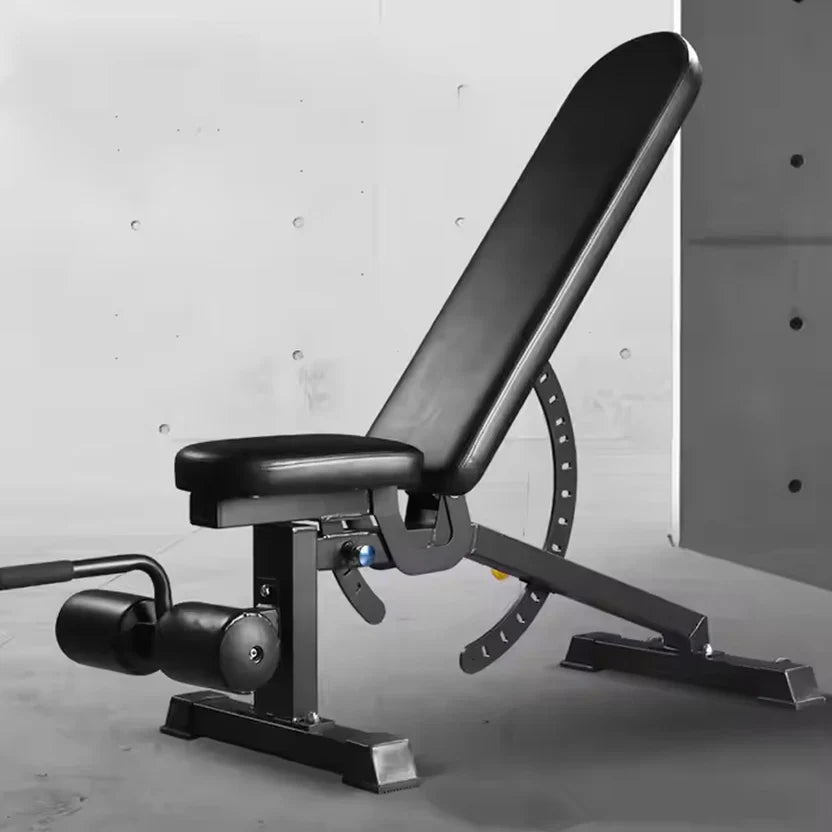 Black adjustable weight bench against a gray concrete wall.