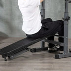 Person using a black adjustable weight bench in a home gym setting.
